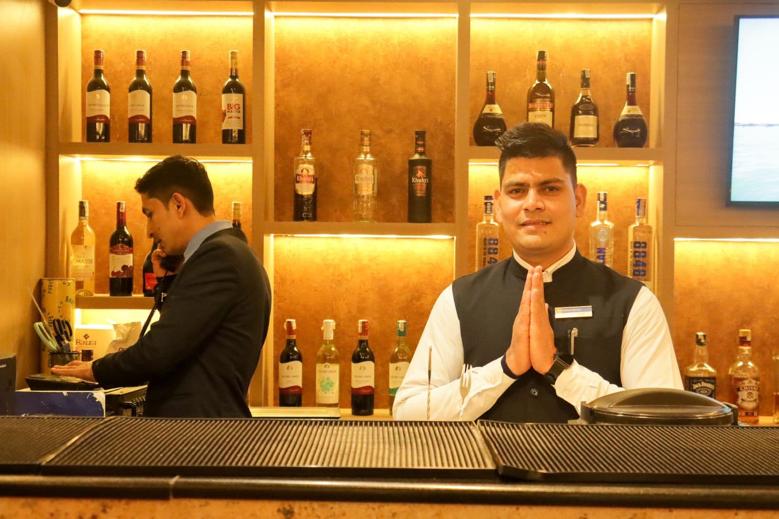 Hotel staff greeting guests at a bar
